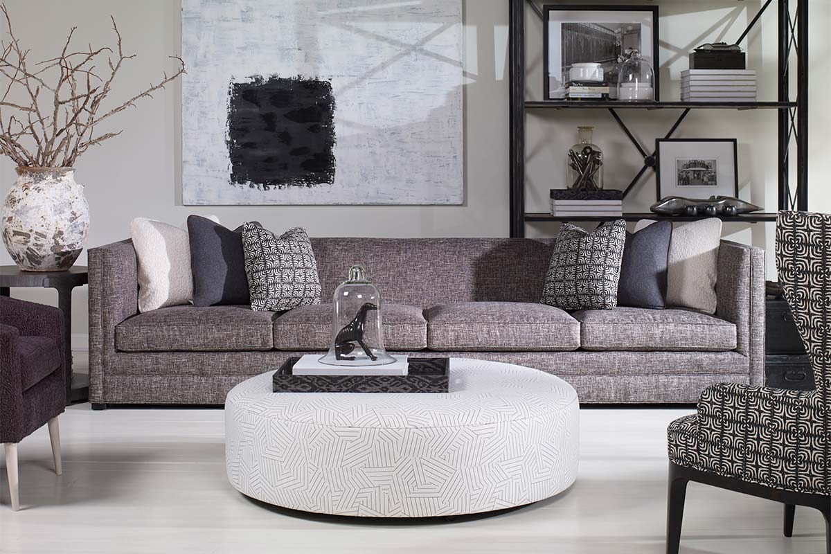 A living room set of furniture including a couch, two chairs, and an ottoman from Century Furniture.